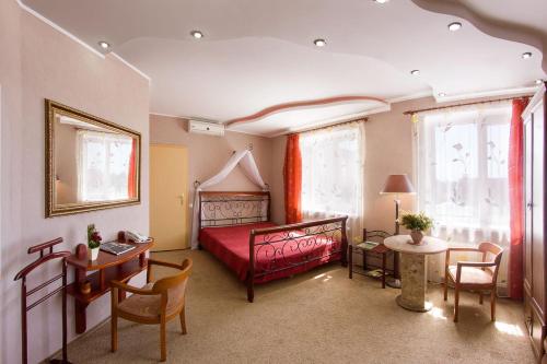 クレメンチュークにあるPantagruelのベッドルーム1室(赤いベッド1台、テーブル、椅子付)