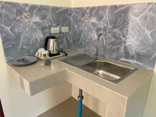 a kitchen with a sink and a counter top at Budchui Guesthouse in Koh Tao