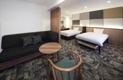 高崎的住宿－高崎華盛頓廣場酒店，酒店客房设有一张沙发和一张床