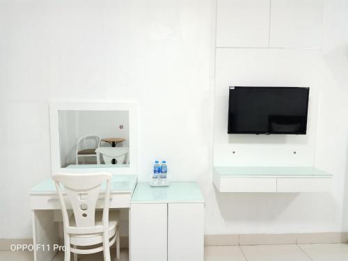 Habitación blanca con escritorio y TV. en Linh Anh Hotel, en Hanói