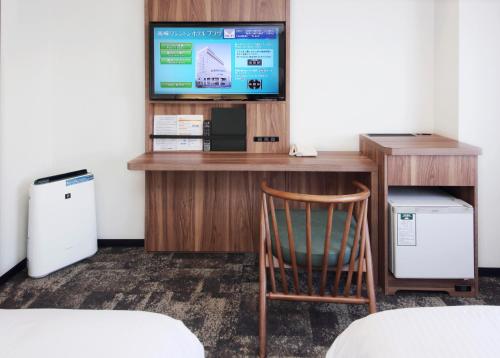 a room with a desk with a tv and a chair at Takasaki Washington Hotel Plaza in Takasaki