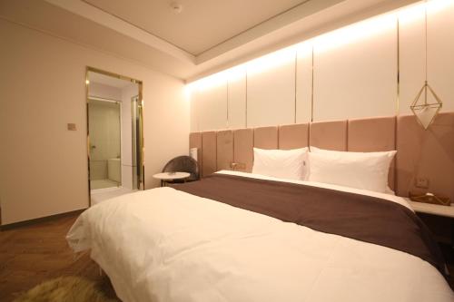 a hotel room with a large bed and a mirror at Den Basta Hotel in Busan