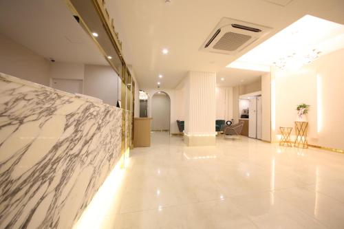 a hallway with a marble wall in a building at Den Basta Hotel in Busan