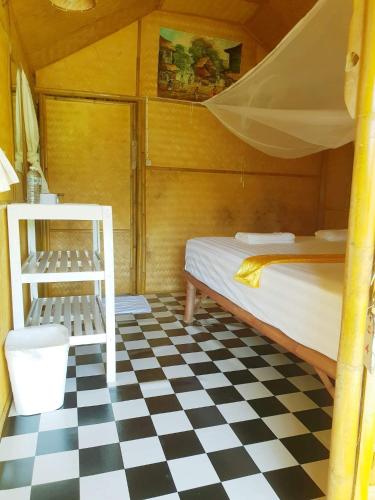 a bedroom with a bunk bed and a checkered floor at Rabbit Bungalow in Ko Phayam
