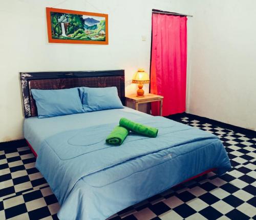 a bed with a green object on top of it at Tereng Wilis bungalows in Tetebatu