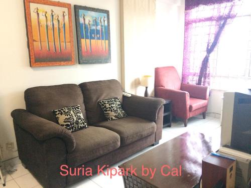 a living room with a couch and a chair at Cozy Master Room at Suria Kipark Damansara Apartment Homestay Sleeps 3 in Kepong