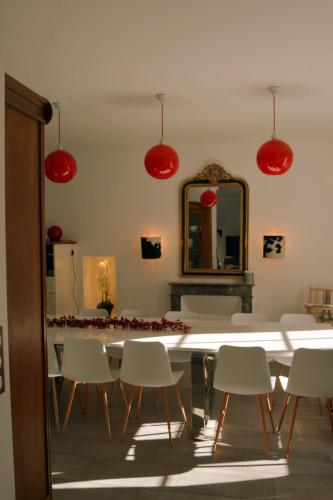 une salle à manger avec des lumières rouges, une table et des chaises dans l'établissement Gîte Illixo, à Luchon