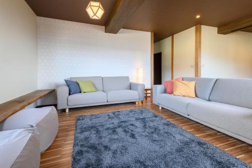 a living room with two couches and a rug at Iroha Nozawa in Nozawa Onsen