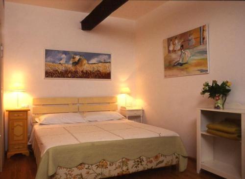 a bedroom with a bed and two pictures on the wall at Agriturismo La Vecchia Dolceacqua in Dolceacqua