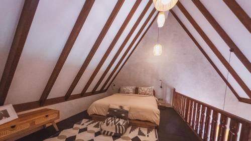 een slaapkamer met een bed in een kamer met houten balken bij Little Ripper Boutique Loft Studio in Tanah Lot