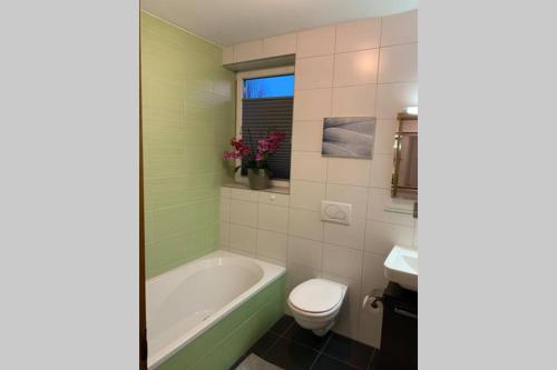 a bathroom with a tub and a toilet and a sink at Appartement Zauner in Oberndorf bei Salzburg