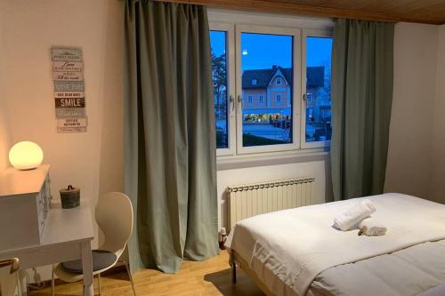 a bedroom with a bed and a desk and a window at Appartement Zauner in Oberndorf bei Salzburg