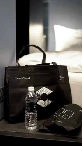 a bottle of water and a bag on a table at CapsuleTransit Airside KLIA T2 - Airport Hotel - International Departure near to Transit Hall, Gate Q in Sepang