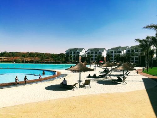 um grupo de pessoas sentadas na praia perto de uma piscina em The Blyde Crystal lagoon Pretoria em Pretoria