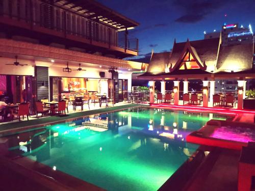 a swimming pool at night with a restaurant at Prime Asia Hotel in Angeles
