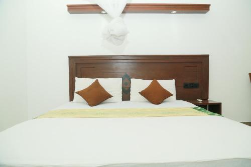 a bed with a wooden headboard and pillows at Suwa Arana Resort in Mirissa