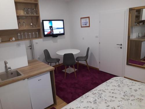 a small room with a table and a tv on the wall at Apartmani Exit in Pale