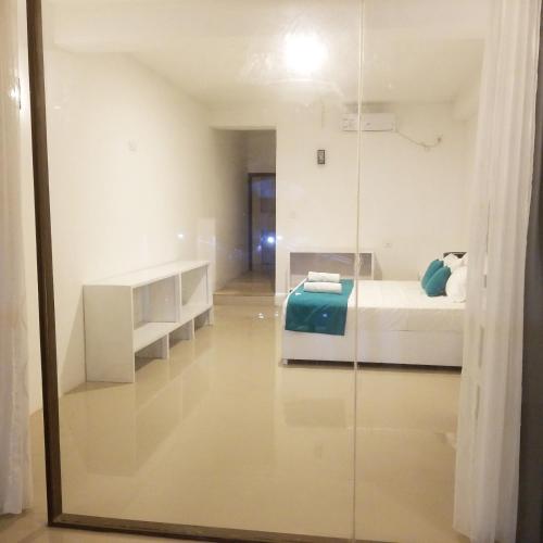 a bedroom with a bed and a glass wall at One World Mirissa in Mirissa