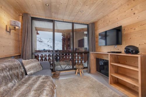 ヴァル・トランスにあるVal Thorens - Cosy Appartement avec Vue Silveralp 224のソファと大きな窓のあるリビングルーム