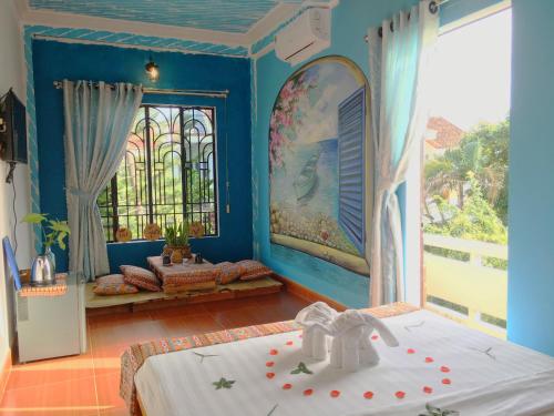 Habitación azul con cama y ventana en Longan Homestay, en Hoi An