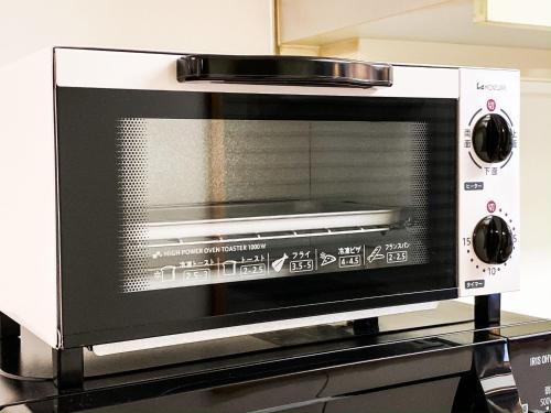 a microwave oven sitting on top of a counter at Yahiro 4-chome House 2F,3F in Tokyo