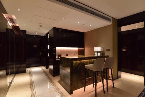 a kitchen with a bar with stools in a room at Vignette Collection Haikou Yatter Hotel by IHG in Haikou