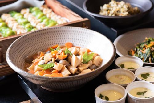a bowl of food on a table with other dishes at Hotel Vista Fukuoka Nakasu-Kawabata in Fukuoka