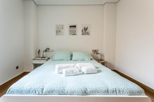 1 dormitorio blanco con 1 cama con 2 almohadas en APARTAMENTO EN PRIMERA LINEA DE PLAYA RiAZOR, en A Coruña
