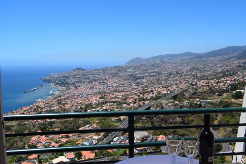 a view of a city from a table with wine glasses at Bay View Apartment in Funchal