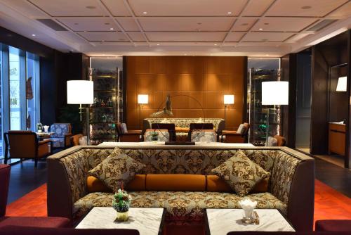 a living room with a couch in a hotel lobby at Vignette Collection Haikou Yatter Hotel by IHG in Haikou