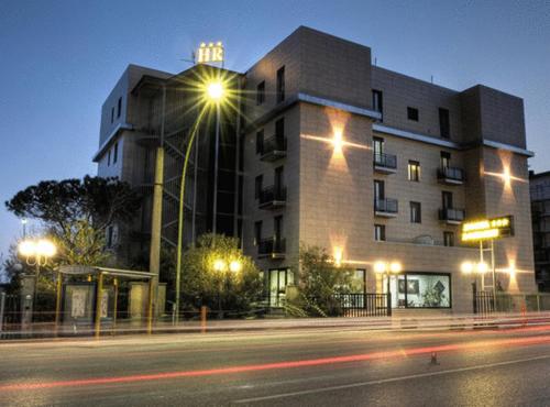 ein großes Gebäude mit Straßenbeleuchtung davor in der Unterkunft Hotel Rondine in Marinella di Sarzana