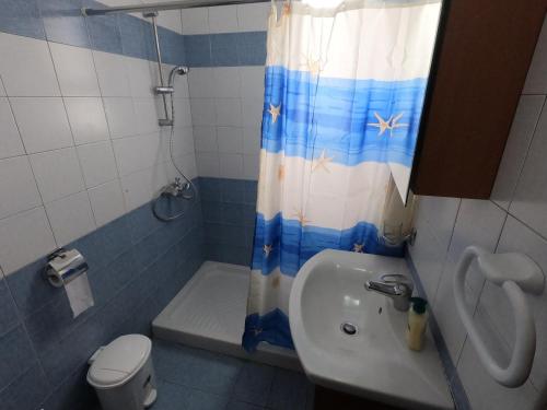 a bathroom with a sink and a toilet and a shower curtain at Amelia Two Bedroom Apartment - 201 in Paphos