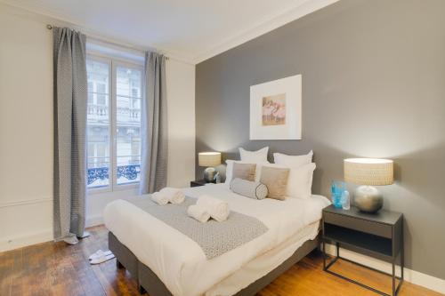 une chambre avec un grand lit avec deux serviettes dessus dans l'établissement Sweett - Boetie V, à Paris