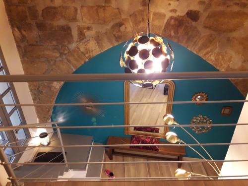 a spiral staircase with a blue wall and a mirror at CENTRE HISTORIQUE T3 DUPLEX PARKING Gratuit in Béziers