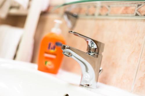 a bathroom sink with a faucet and a bottle of soap at Arpad Bridge Apartments in Budapest