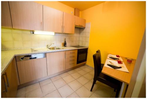 a kitchen with a sink and a table with a chair at Arpad Bridge Apartments in Budapest