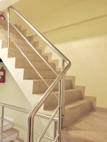 a staircase with a metal railing in a house at Thai Orchid Guest House in Jomtien Beach