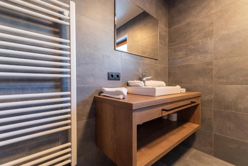 een badkamer met een wastafel en een spiegel bij A CASA Aquamarin in Sölden