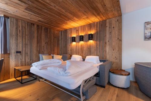 een bed in een kamer met een houten wand bij A CASA Aquamarin in Sölden