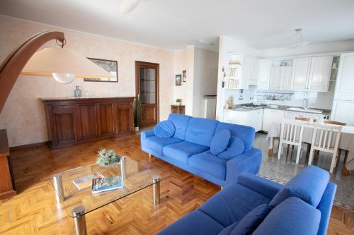 ein Wohnzimmer mit einem blauen Sofa und einem Tisch in der Unterkunft IseoLakeRental - Casa Anita in Riva di Solto