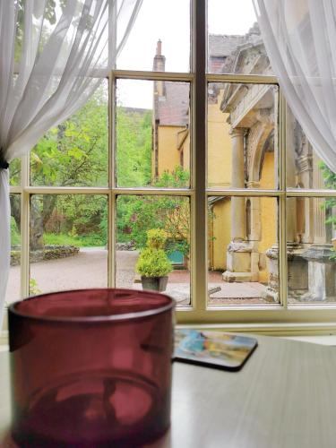 a window with a vase on a table in front of it at Leithen Lodge in Innerleithen