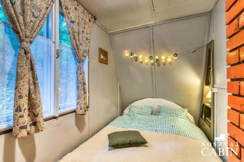 een kleine slaapkamer met een bed en een raam bij Noszvaj Cabin in Noszvaj