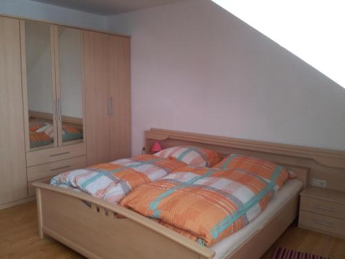 a bedroom with a bed with an orange and blue comforter at Wohnen mit Panoramablick in Gramastetten
