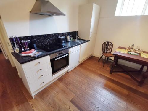 a kitchen with a sink and a stove and a table at Leithen Lodge in Innerleithen