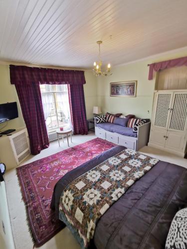 a bedroom with a large bed and a couch at Leithen Lodge in Innerleithen