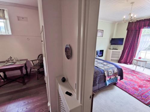a bedroom with a bed and a dining table at Leithen Lodge in Innerleithen