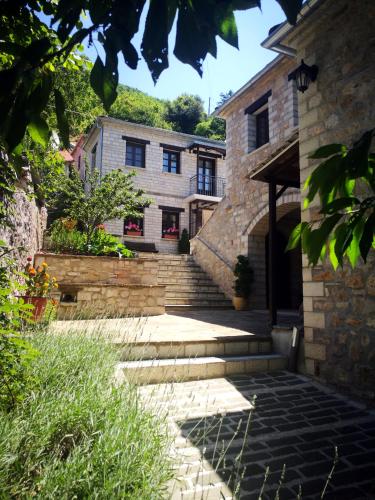 a stone house with stairs leading to a building at Guesthouse Lucas in Zagori