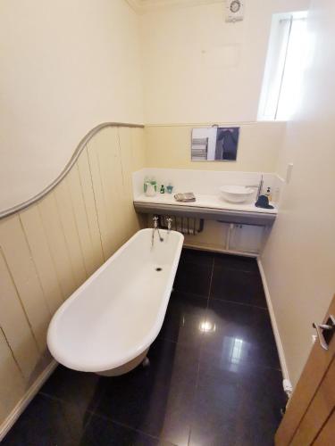 a bathroom with a white tub and a sink at Leithen Lodge in Innerleithen