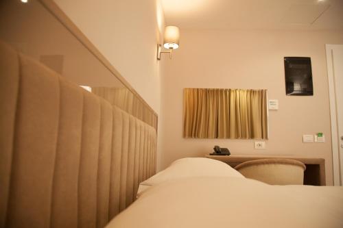 a bedroom with a bed and a desk and a mirror at Royal G Hotel and Spa in Durrës