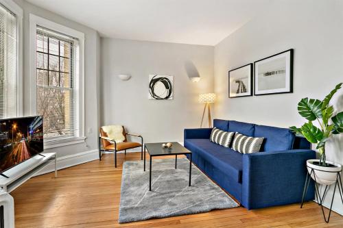 a living room with a blue couch and a tv at Cool 2BR Apartment close to Fun City - Grace 2 in Chicago